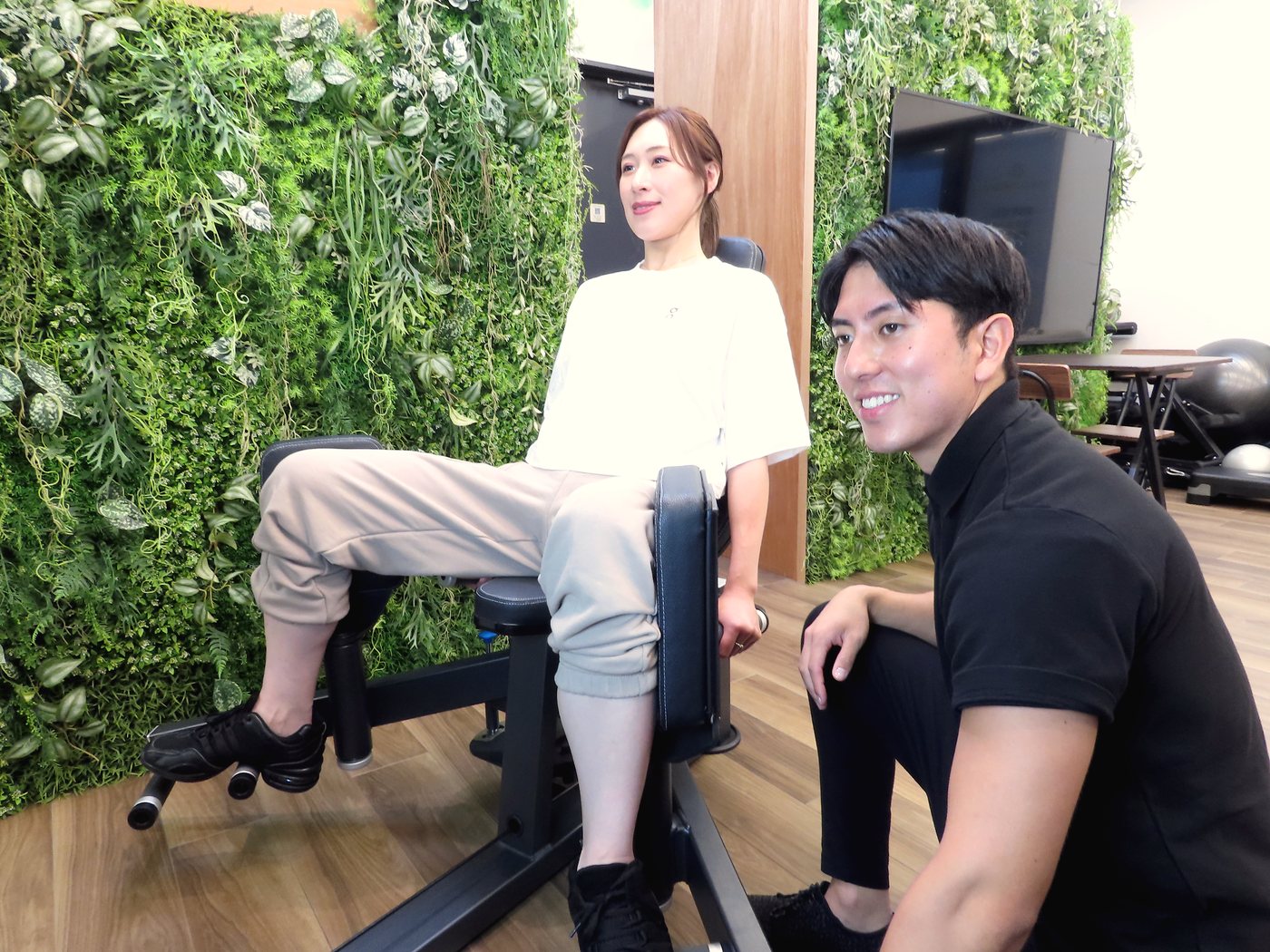 トレーナーと一緒にマシントレーニングをする女性|FITNESS CLUB SPEX 白山店